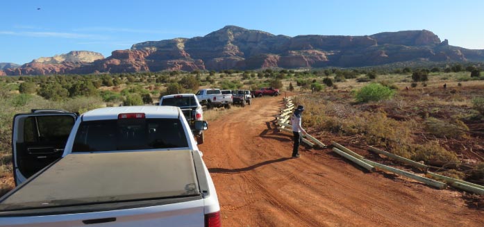 Pickup trucks line a worm fence being constructed along Diamondback Gulch to delineate the OHV corridor and protect fragile ecosystems.