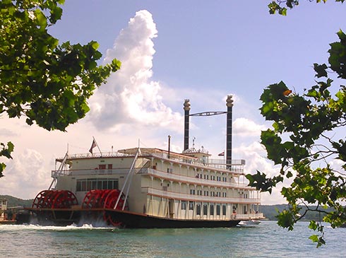Rear view of the Branson Bell Showboat on Table Rock Lake with its red paddle wheels in motion.