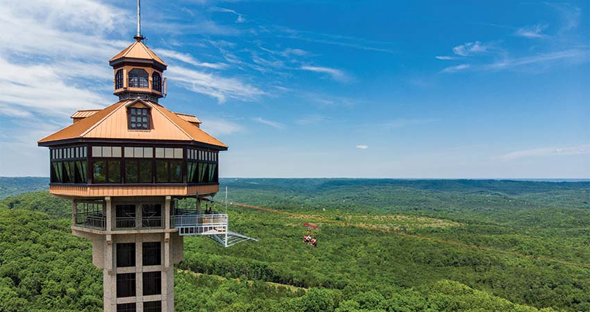 View of the Inspiration Tower overlooking the legendary Shepherd of the Hills in Branson, Missouri with a deep blue sky.