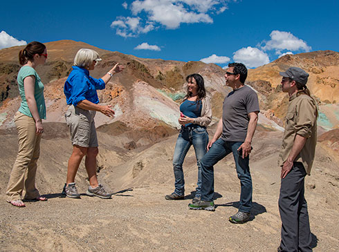 Pink Adventure guide and tour guests at the colorful Artists Palette viewpoint at Death Valley National Park, CA.