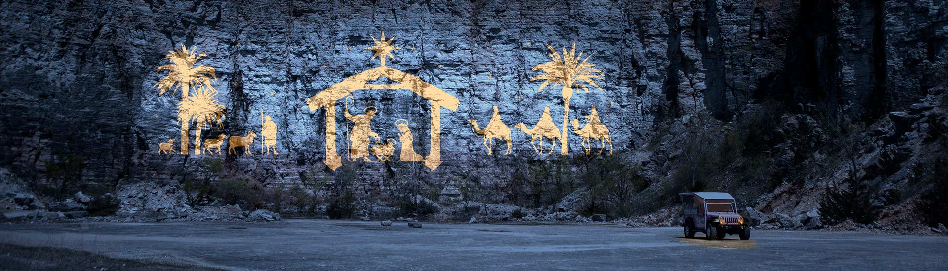 Christmas manger and nativity scened illuminated against the cliff face of Baird Mountain during Pink Jeep Tours Branson Christmas tour.