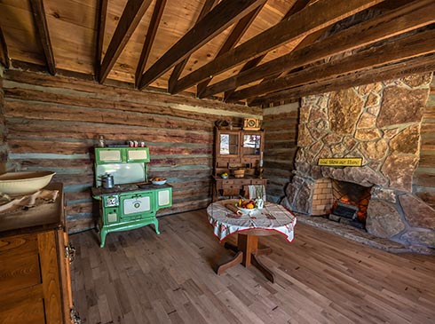 Interior of a historic log cabin atop Baird Mountain, exclusive site accessed with  Pink Jeep Tours Branson, MO.