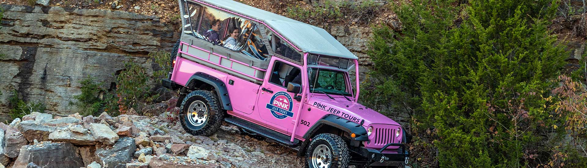 A Pink Jeep Wrangler navigates a steep, rocky downhill 4x4 trail into the Baird Mountain Quarry, Branson, Missouri.