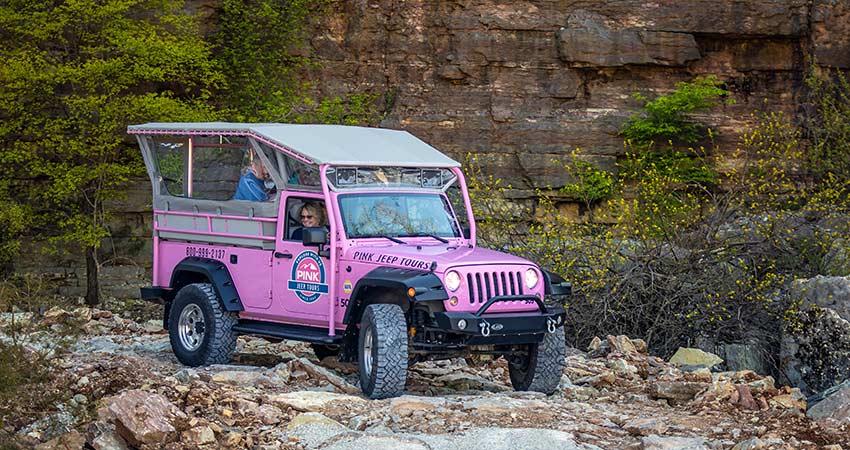 A custom Pink Jeep Wrangler descends a rocky trail along the limestone face of the Baird Mountain Quarry, Branson, MO.