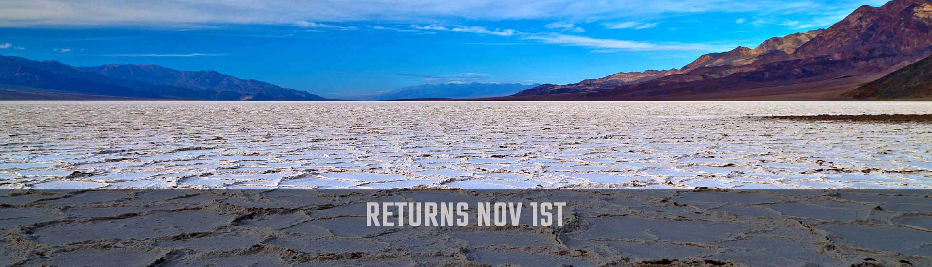 Death Valley National Park tour image of white salt flats with Returns Nov 1st banner.