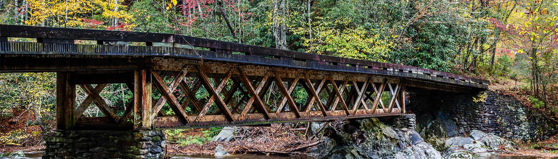 Antique, steel bridge crossing over the Little River in Elkmont, near Great Smoky Mountains National Park during Fall.