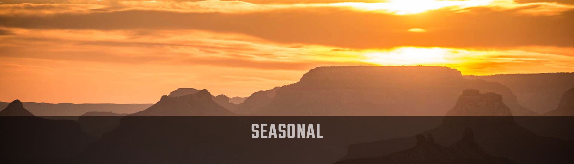 Golden sun sets behind the jagged edges  of the South Rim of the Grand Canyon, Hermits Rest Hike & Jeep Sunset Tour Seasonal banner.