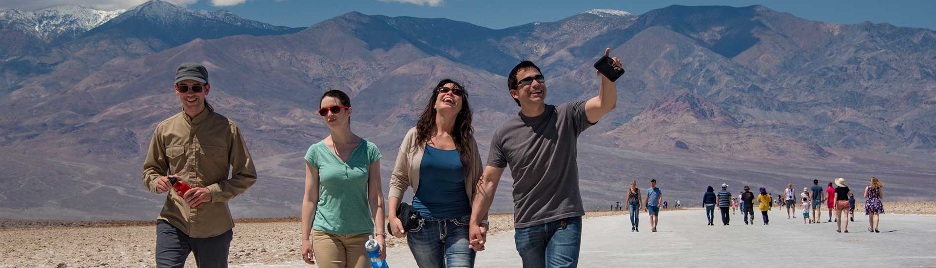 Tourists walking on the salt flats at Badwater Basin, Death Valley National Park tour, Pink Jeep Tours.