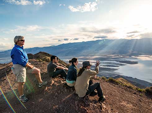 Group of people viewing Death National Valley Park from Dante's View at sunset with a tour guide.