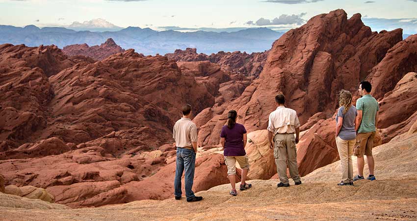 Pink Jeep Las Vegas Tour guide and two couples enjoying a close-up view of the rocky sandstone landscape at Valley of Fire State Park.