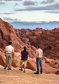Pink Jeep guide with couple look out over the geological formations of Valley of Fire State Park, Nevada