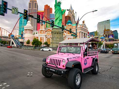 Guests in an open-air Pink Jeep ride past the Statue of Liberty by the New York New York Hotel in Las Vegas