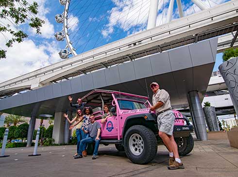 Guests pose for photo ops around an an open-air, Pink Jeep on the Las Vegas Sights and Sounds tour