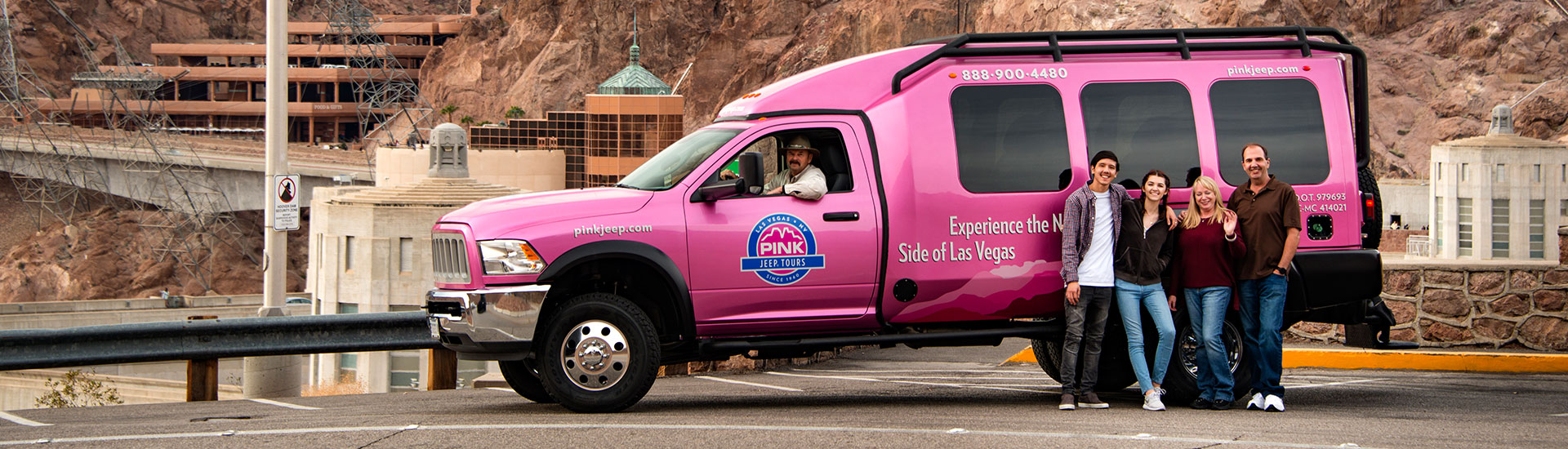 Four tour guests pose in front of a Pink Adventure Tour Trekker at Hoover Dam, during the Pink Jeep Tours Hoover Dam Classic Tour.