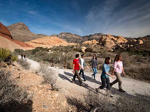 Pink Jeep tour group walking on a trail in  Red Rock Canyon near Las Vegas, Nevada