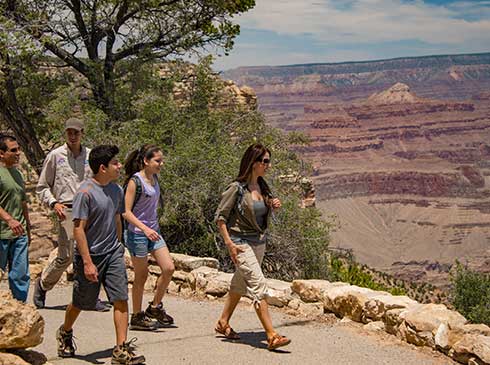 Pink® Jeep® guests and tour guide walking the Trail of Time from Yavapai Point to Grand Canyon Village