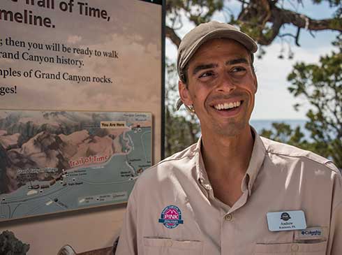 Pink® Jeep® certified guide standing by Trail of Time timeline map at Grand Canyon National Park