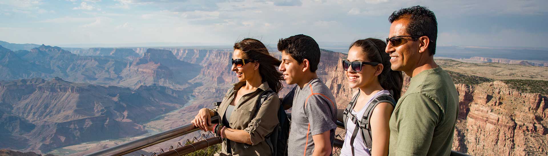 Close-up view of a family looking out over the Grand Canyon's South Rim on Pink Jeep Tours Desert View Tour.