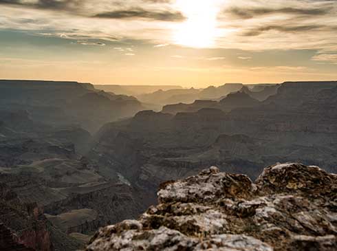 Golden sunset with the shadowed Grand Canyon cliffs in foreground, Pink Jeep® Tours Desert View Sunset Tour.