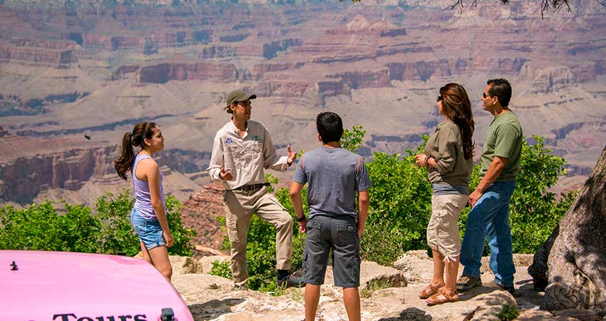 Pink Jeep® Tour guide talking with guests while overlooking the Grand Canyon's South Rim.