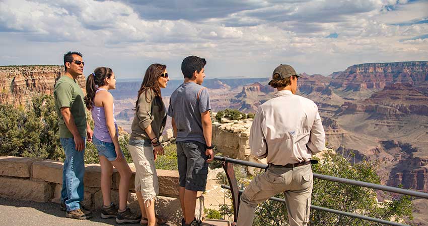 Pink Jeep Tour Guide and guests at a lookout point along the South Rim of Grand Canyon National Park.