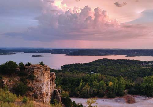 A view from Baird Mountain across Table Rock Lake, which reflects the colorful clouds of a sunset.