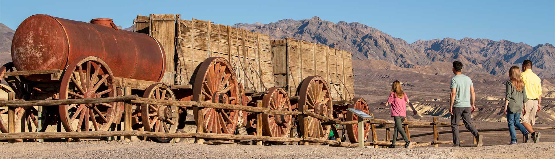 Pink Adventure Tours Death Valley Tour guests approaching the Twenty-Mule Team Wagon replica, Harmony Borax Works, Death Valley