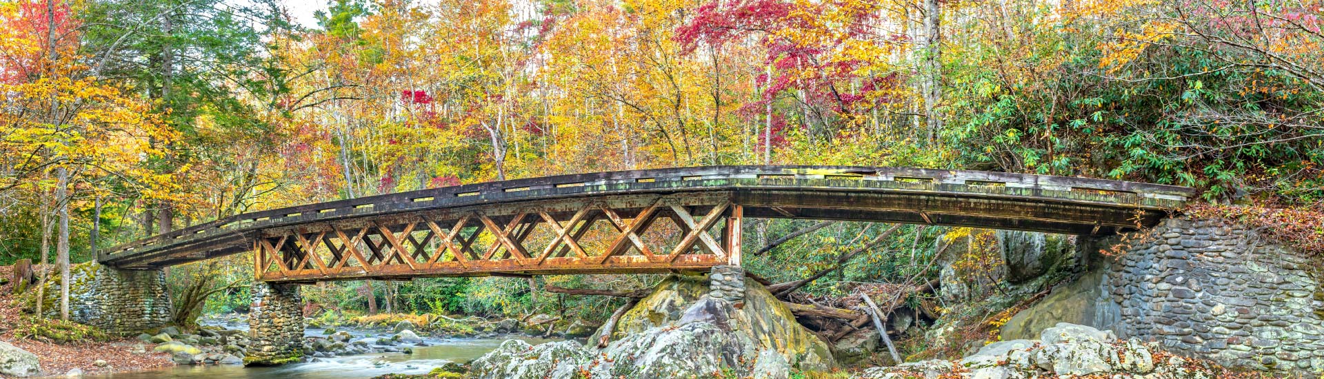 Bridge near historic town of Elkmont in Great Smoky Mountains National Park, TN, surrounded by fall foliage.
