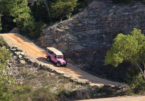 A Pink Jeep descends a steep trail into the Baird Mountain quarry.
