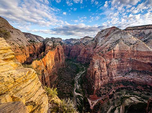 Aerial view of the Virgin River flanked by the colorful, steep canyon walls of Zion National Park, Pink Adventure Tours day trip from Las Vegas.