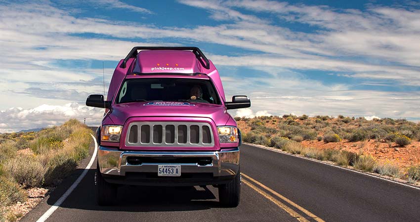 Front-end view of Pink Jeep Tour Trekker traveling through Mohave Desert en route to Grand Canyon West Rim