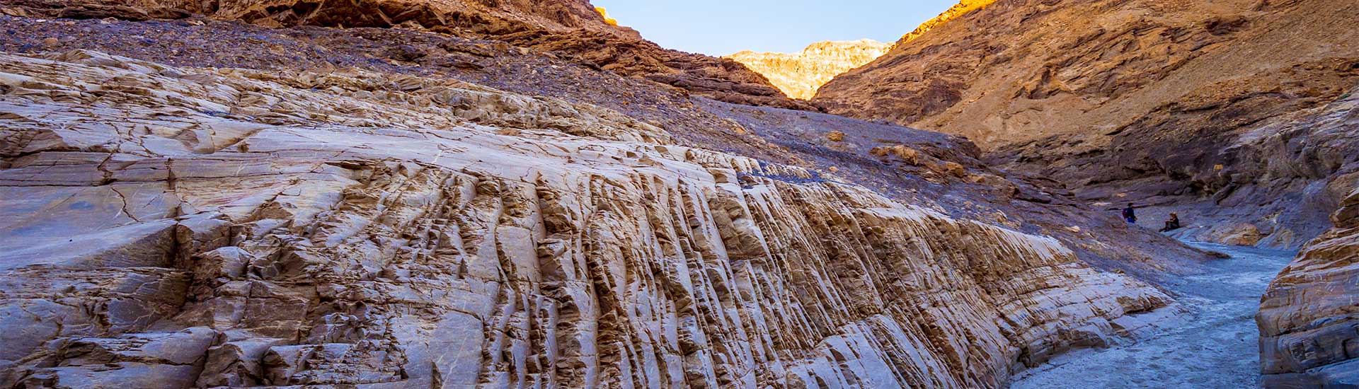 Colorful stratified breccia rock formations line Mosaic Canyon under the morning light at Death Valley National Park, CA.
