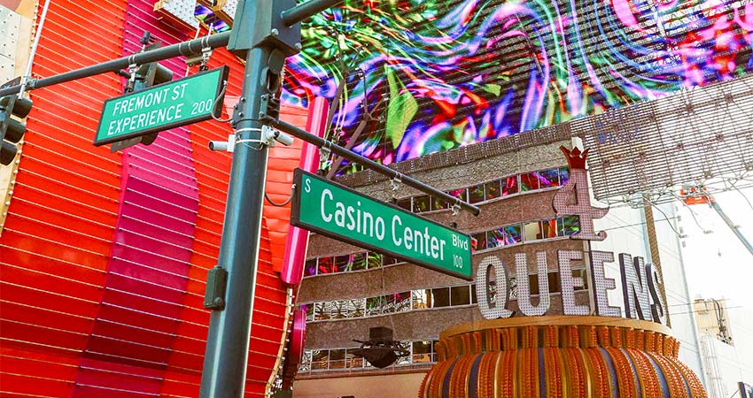 Vibrant image of the Freemont Street Experience and Casino Center crossroads signage during daytime with neon signage above.