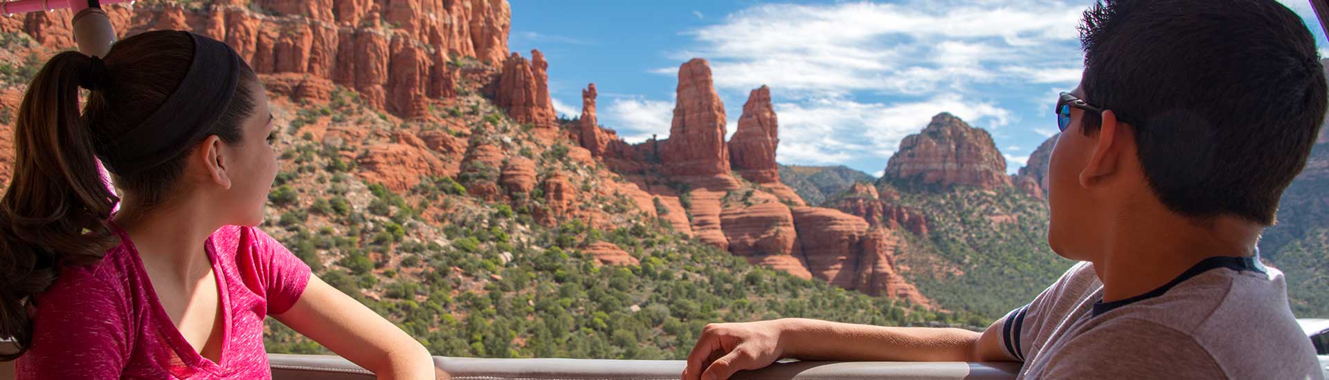 Two teenagers looking out towards the red rocks surrounding the Chapel of the Holy Cross on the Scenic Sedona Chapel Bells tour.