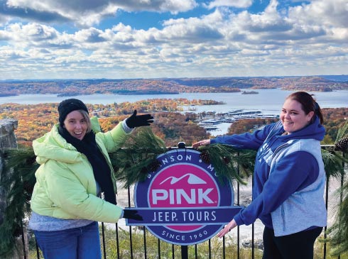Friends posing on the festive Baird Mountain patio overlooking Table Rock Lake in fall, Branson, MO.