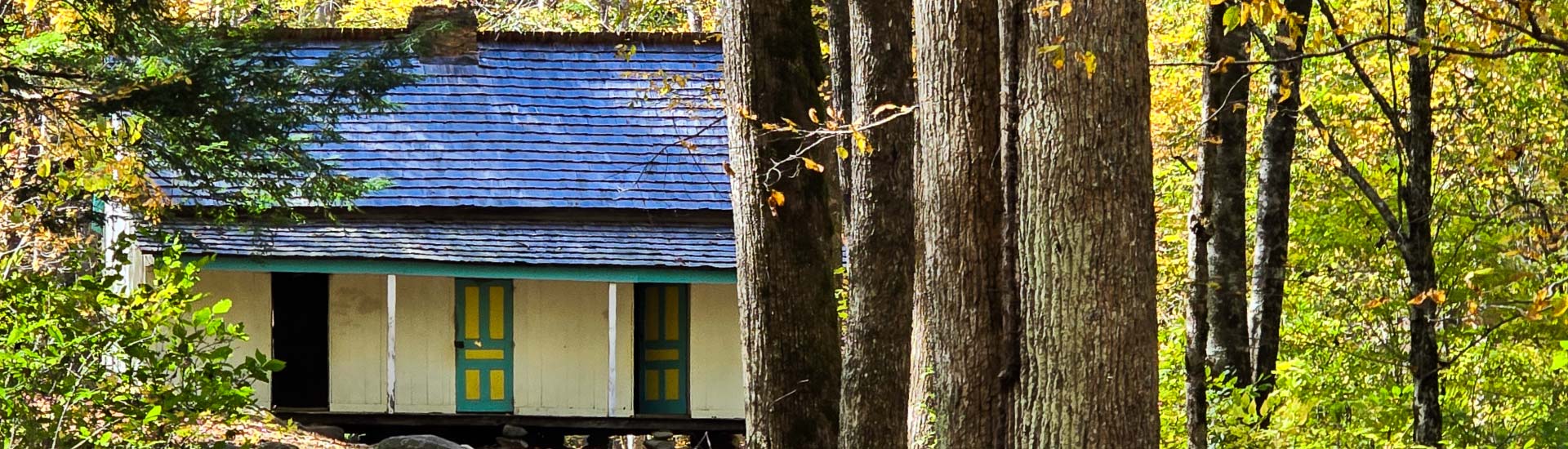 A Smoky Mountain cabin tucked into colorful fall foliage on the Pink Jeep Tours Newfound Gap Tour.