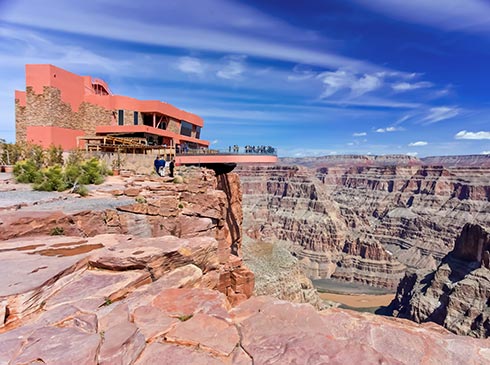 The Grand Canyon Skywalk Terminal and Skybridge overlooking the West Rim and Colorado River below, with a  beautiful blue sky above.