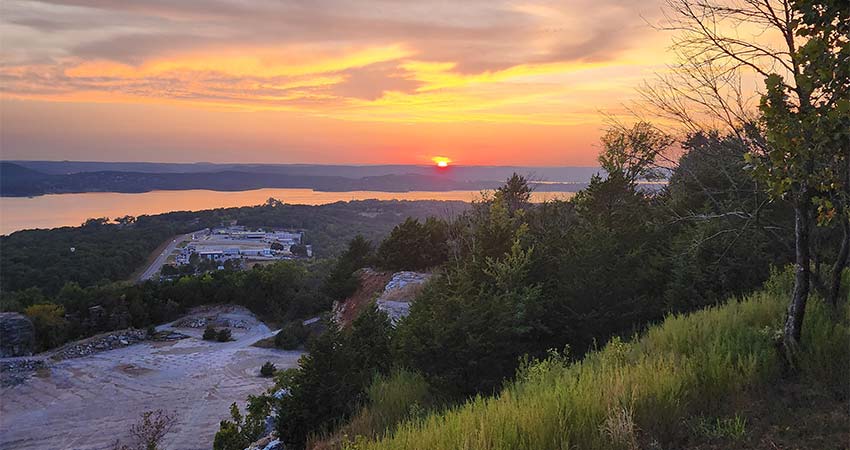 View of Table Rock Lake and the quarry below Baird Mountain during a violet and orange sunset, Pink Jeep Tours Best of Branson tour.