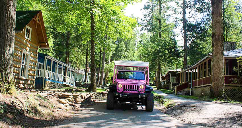 Pink Jeep Tour driving past restored cabins at Daisy Town, Elkmont Ghost Town, Great Smoky Mountains National Park.