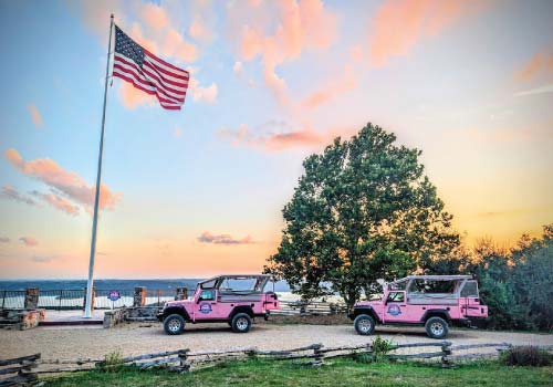 The American flag waves above two Pink Jeeps atop Baird Mountain in Branson, MO