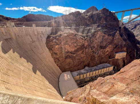 A view down the steep, 726-foot high curve of the Hoover Dam from high above the Colorado River